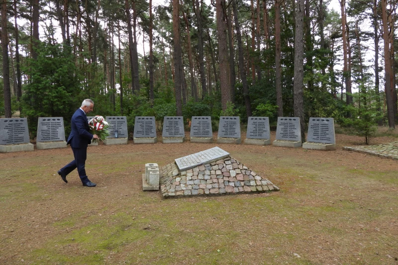 Burmistrz Tadeusz Kowalski sklada wiązankę kwiatów przy Pomniku Pomordowanych w Rudzkim Moście